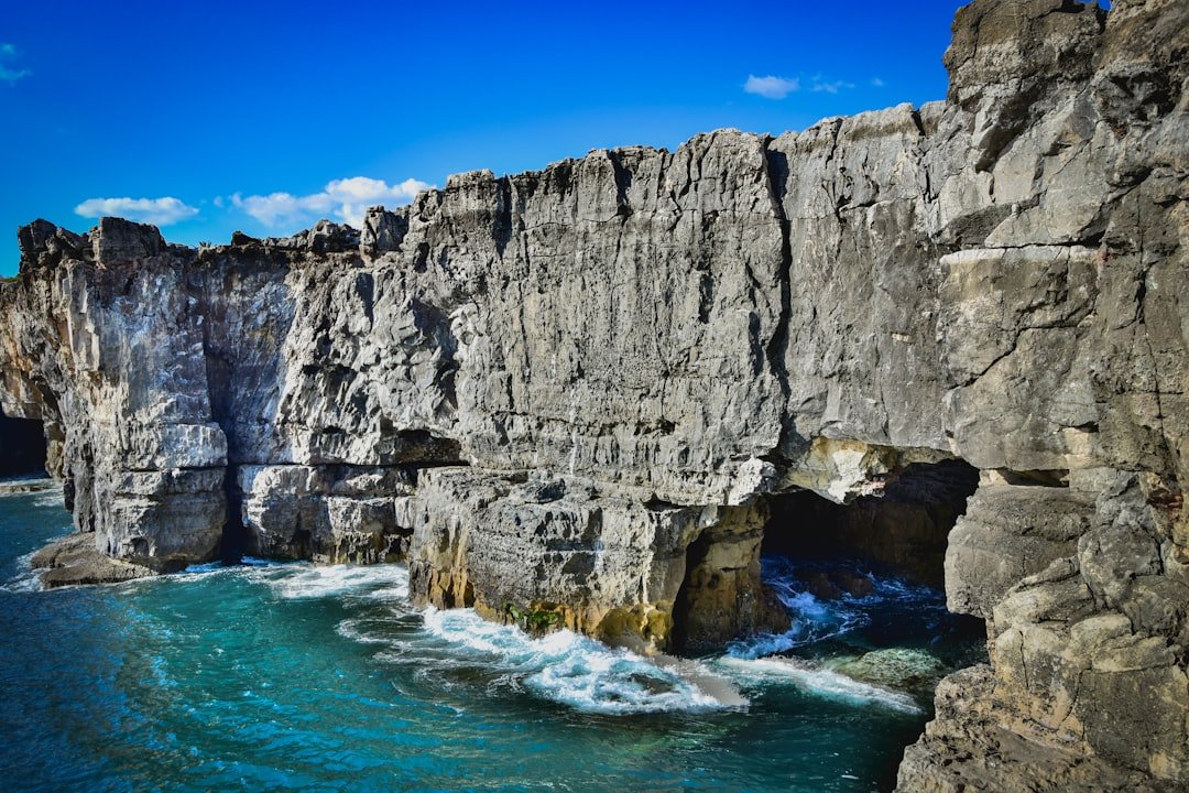 Clifftop rock arch and crashing waves