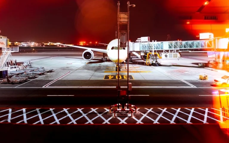 A long exposure of an airplane docked at Abu Dhabi airport at night, highlighting travel and transportation.