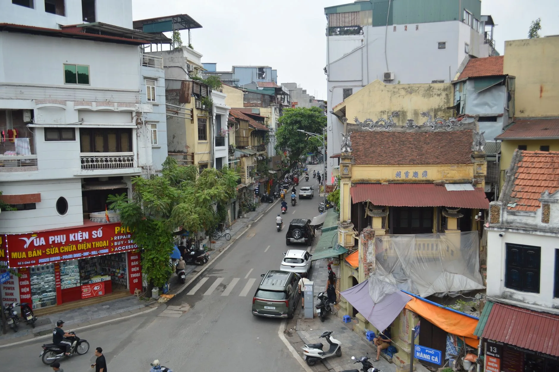 A busy street in Hanoi, Vietnam, showcasing local architecture and city life.