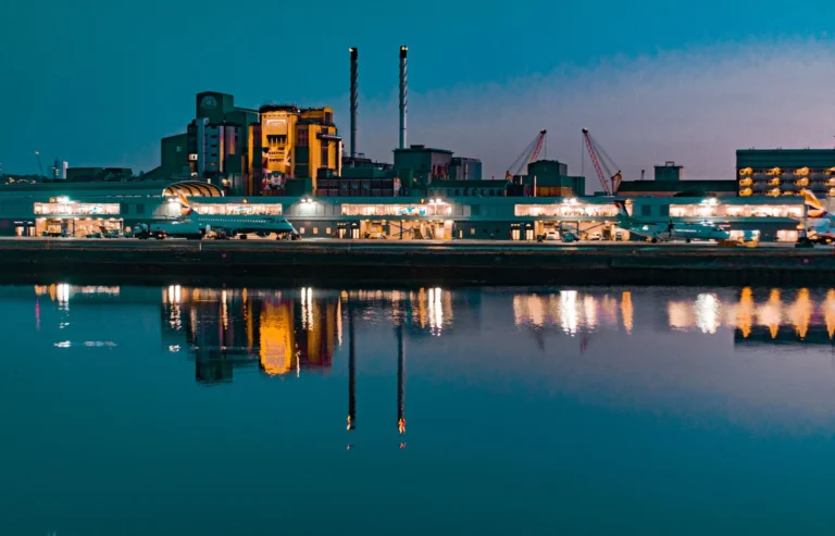 Illuminated skyline at night reflecting in the Thames near London City Airport.