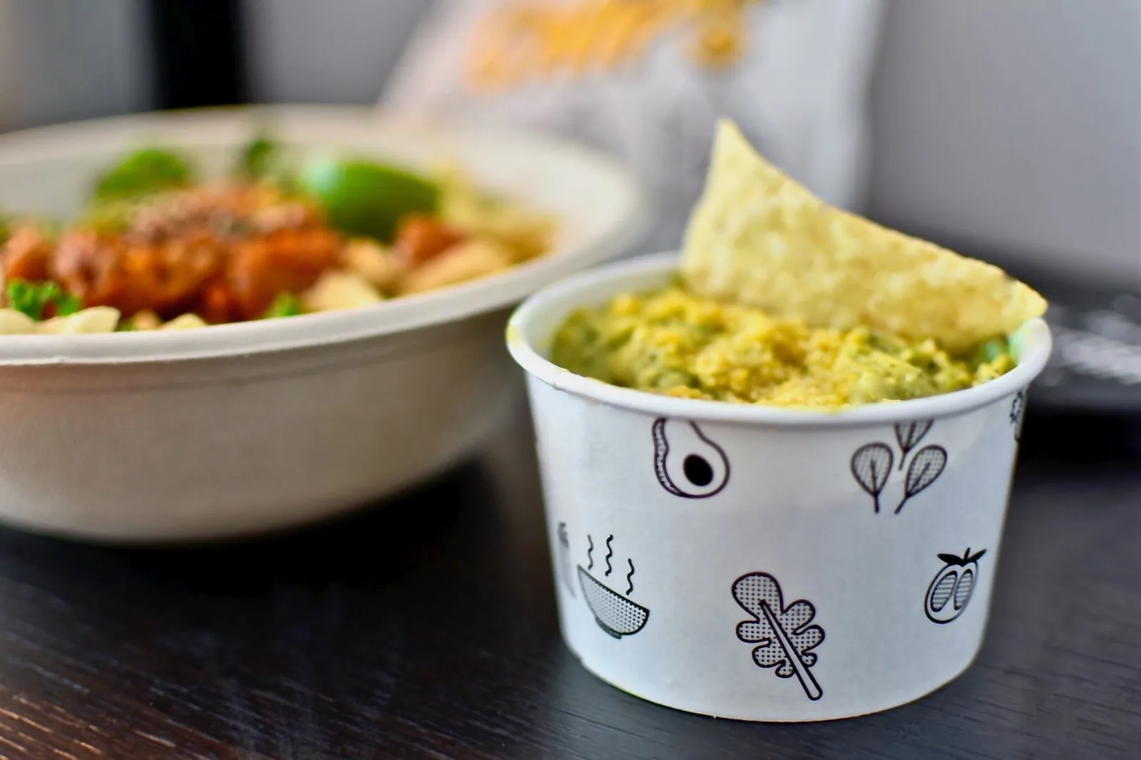 Close-up of tasty guacamole with chips and salad bowl in Boston eatery.