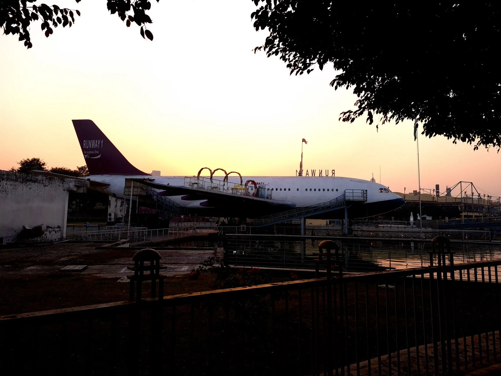 Aerial-themed exhibit with airplane at sunset in Delhi, India. Ideal for travel-themed presentations.