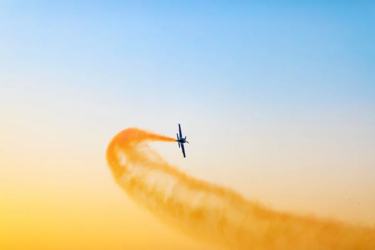 Airplane performing an aerial stunt against a vibrant sky in Dubai, UAE.