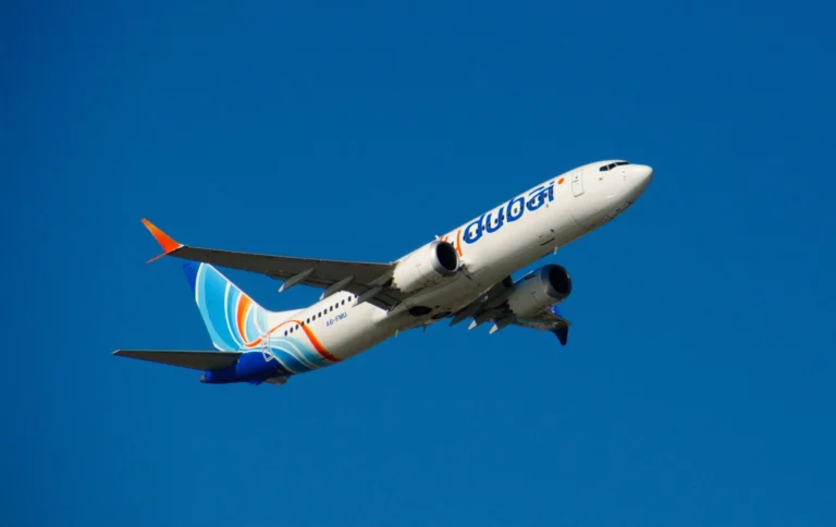 Flydubai plane captured mid-flight against a clear blue sky over the Maldives.