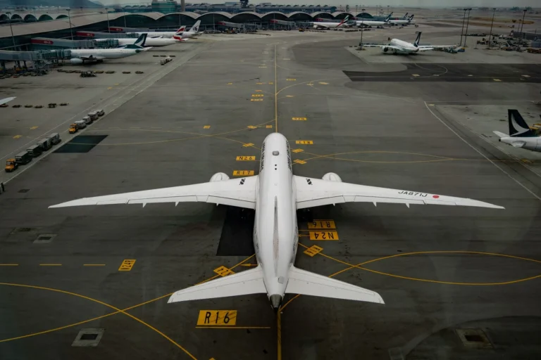An aerial shot of Hong Kong International Airport with planes on the runway and terminal in view.