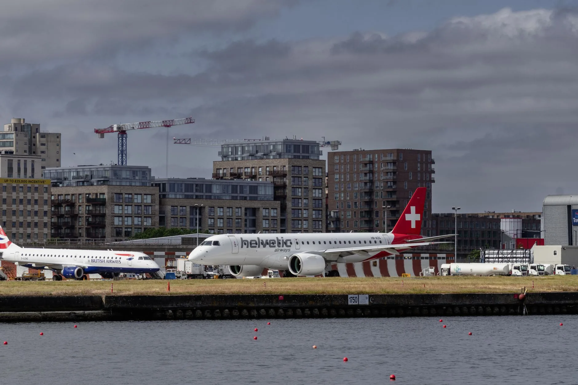 View of British Airways and Helvetic Airways planes at London City Airport.