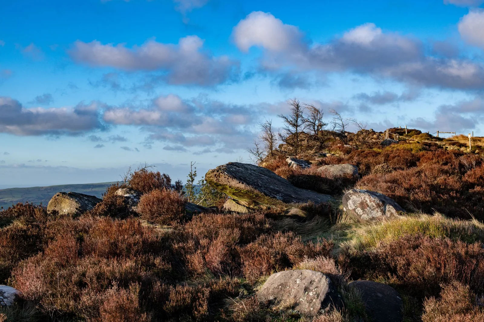 Explore the rugged beauty of the Peak District with rocky landscapes and natural scenery under a vibrant sky.