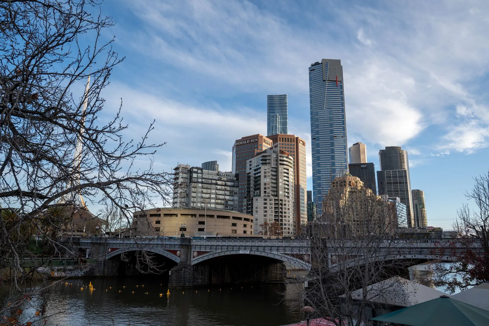 View of Melbourne's skyline and Yarra River on a clear day, showcasing iconic architecture.