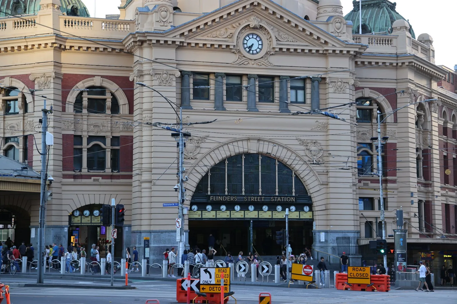 Historic Flinders Street Station in Melbourne bustling with people and city life.