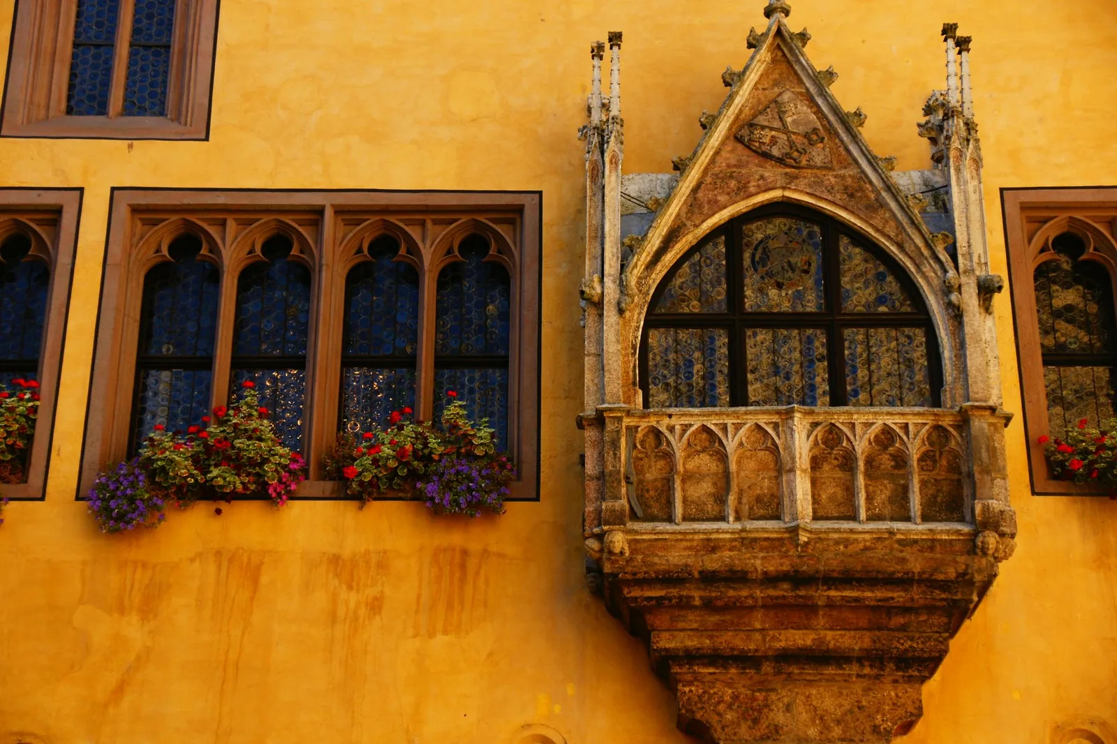 Stunning Gothic architecture with ornate windows and balcony in Munich, Germany.