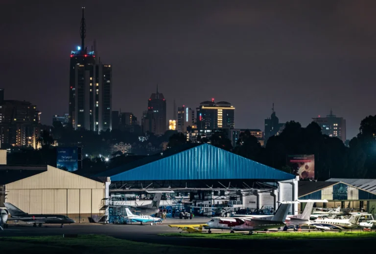 A captivating nighttime view of Nairobi skyline with an airport foreground, highlighting urban life and aviation.