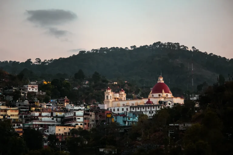Scenic view of the Basilica of Our Lady of Juquila surrounded by lush hills in Oaxaca, Mexico.