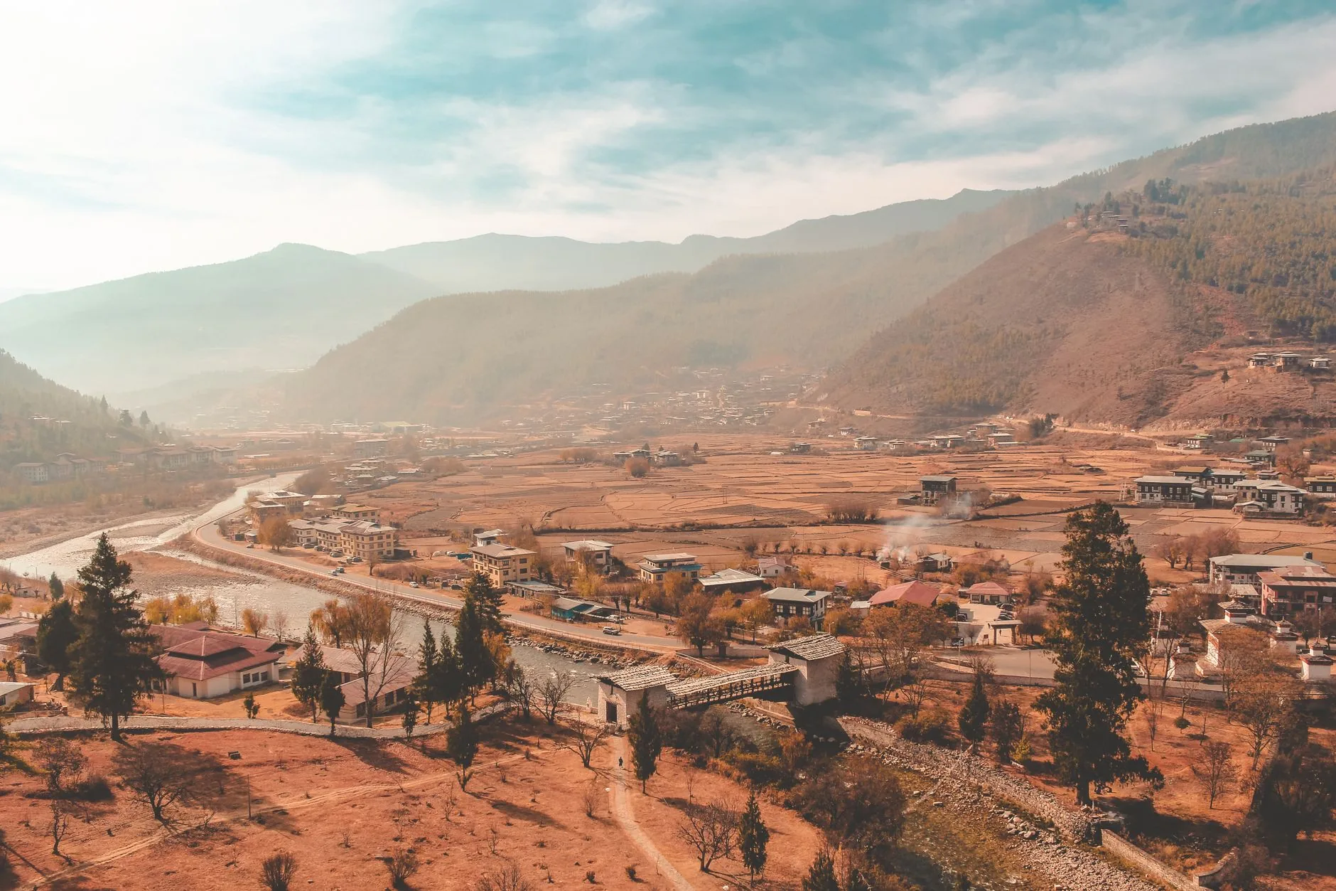 Breathtaking aerial view of a scenic valley in Bhutan, showcasing natural beauty and quaint architecture.