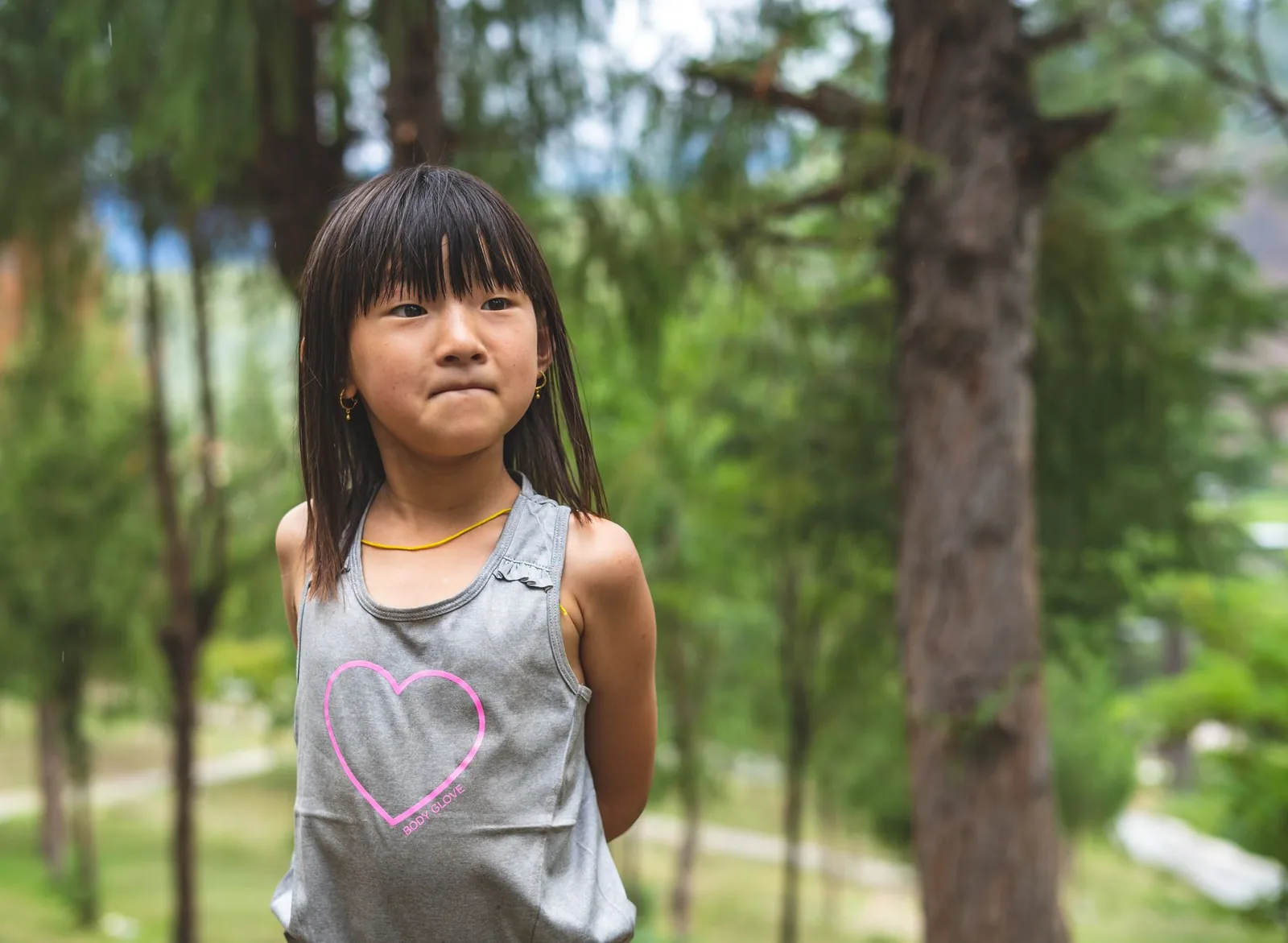 Adorable young girl in a park during summer in Paro, Bhutan, enjoying leisure time.