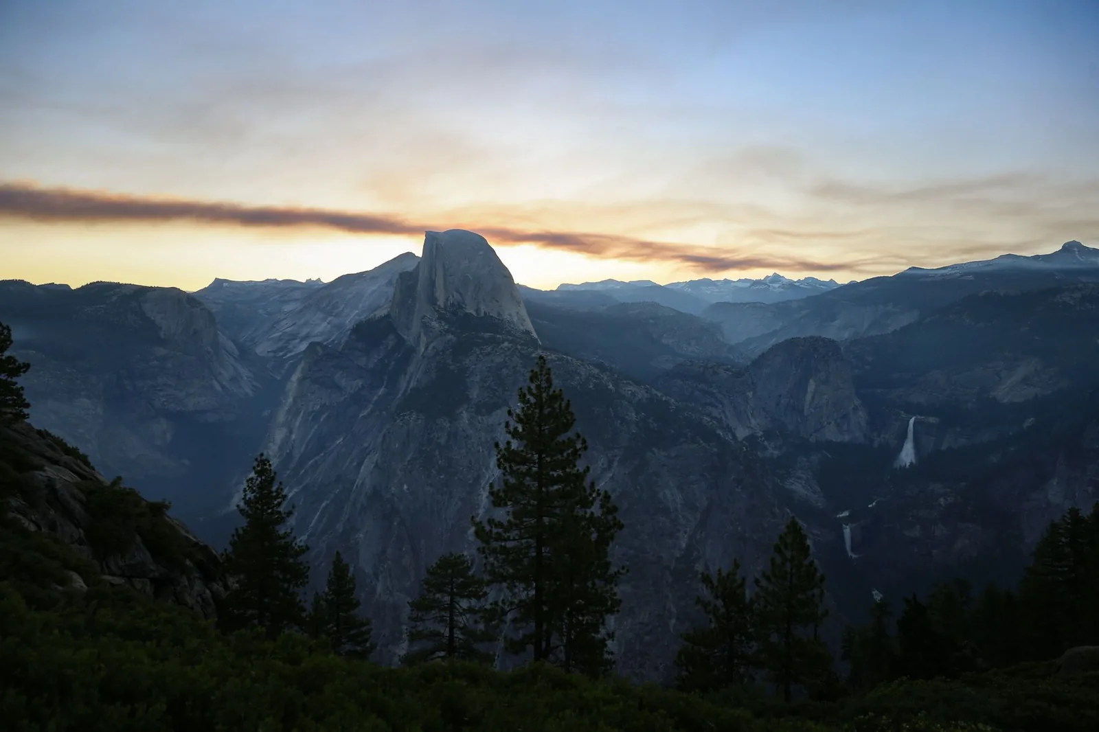 A stunning sunset view of Half Dome in Yosemite National Park, showcasing natural beauty and majestic landscapes.