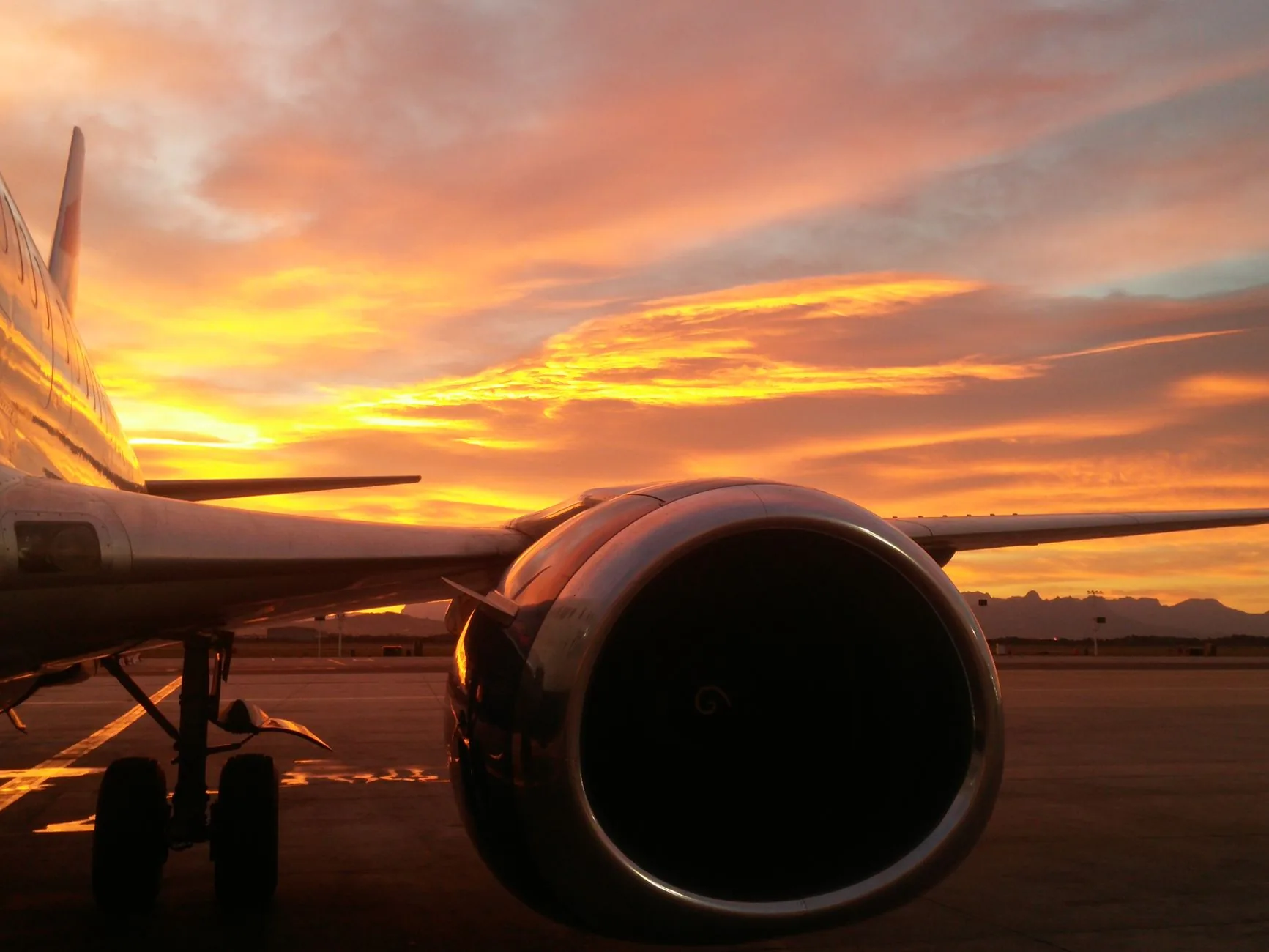 Stunning view of an airplane turbine with a vibrant sunset sky at Cape Town airport.