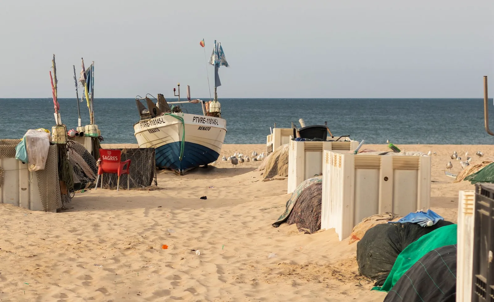 Traditional fishing boats on the sandy shores of Monte Gordo, Portugal's Algarve region.