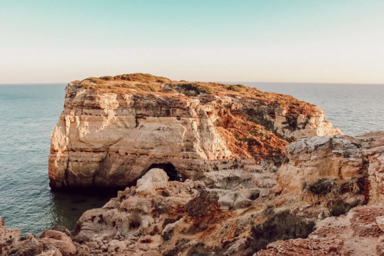 Explore the breathtaking cliffs and ocean views of the Algarve coastline in Faro, Portugal.