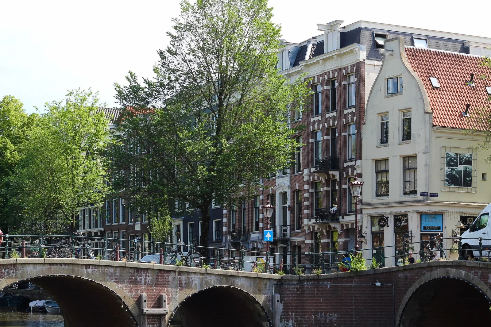 Charming view of historic brick houses and a canal bridge in Amsterdam, Netherlands.