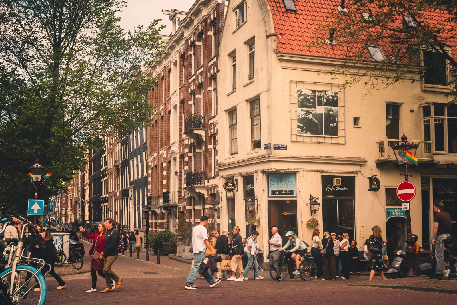 Lively street view in Amsterdam with people and historic buildings.