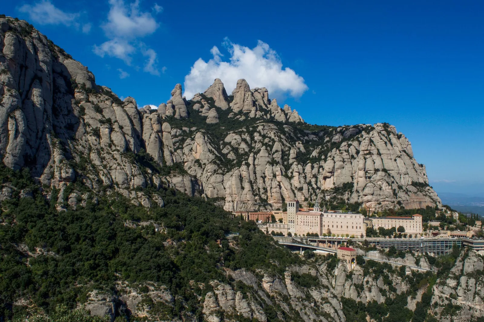 Stunning landscape of Montserrat Mountain and monastery in Catalonia, Spain, under a clear blue sky.