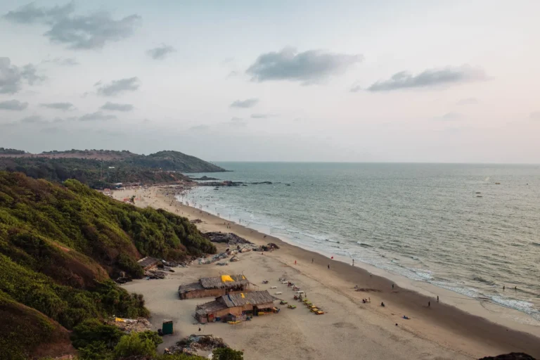 Stunning aerial view of Chapora Beach in Goa, India, showing a serene coastline with lush greenery and soft sands.