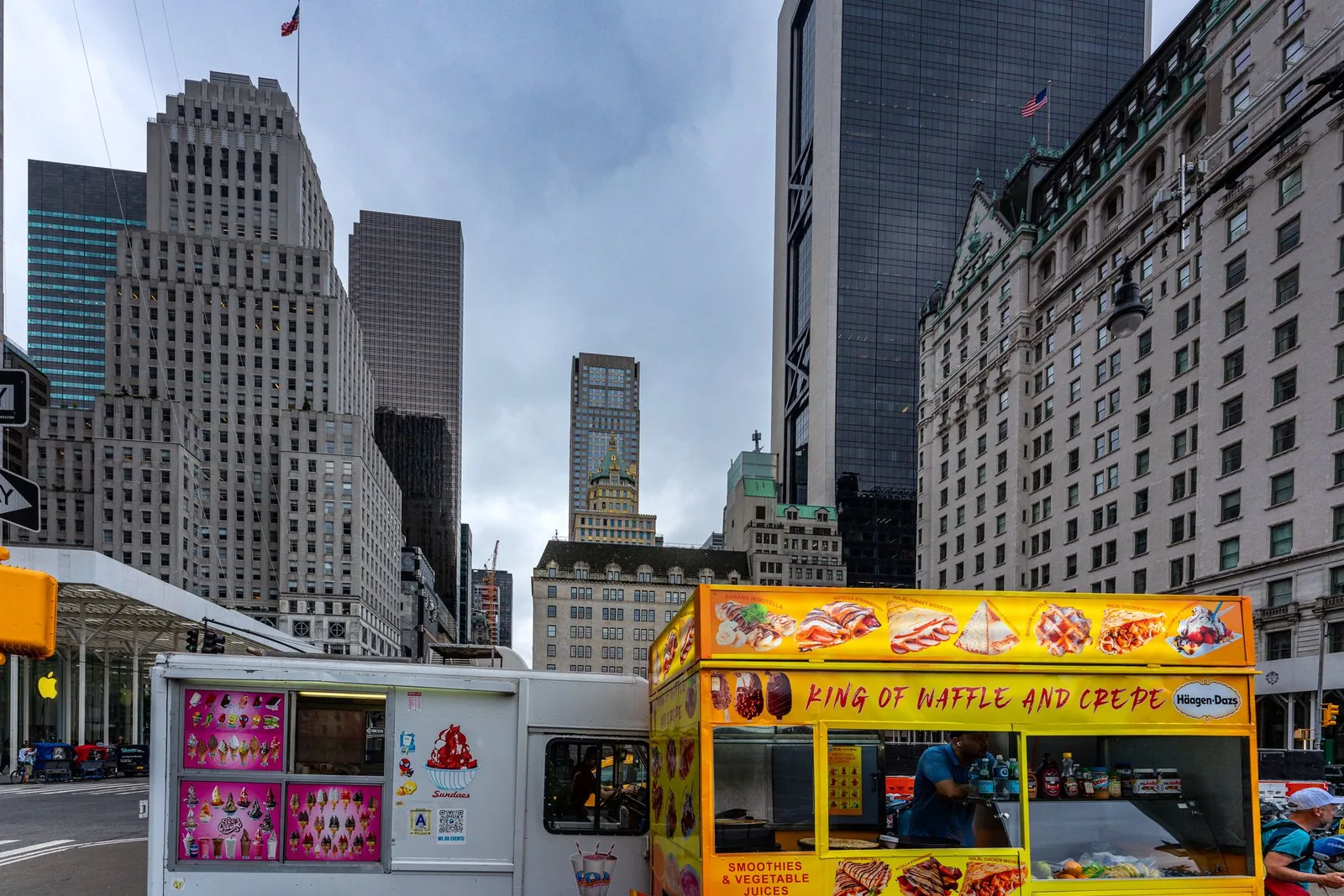Vibrant food cart in Midtown Manhattan with iconic skyscrapers in New York City.