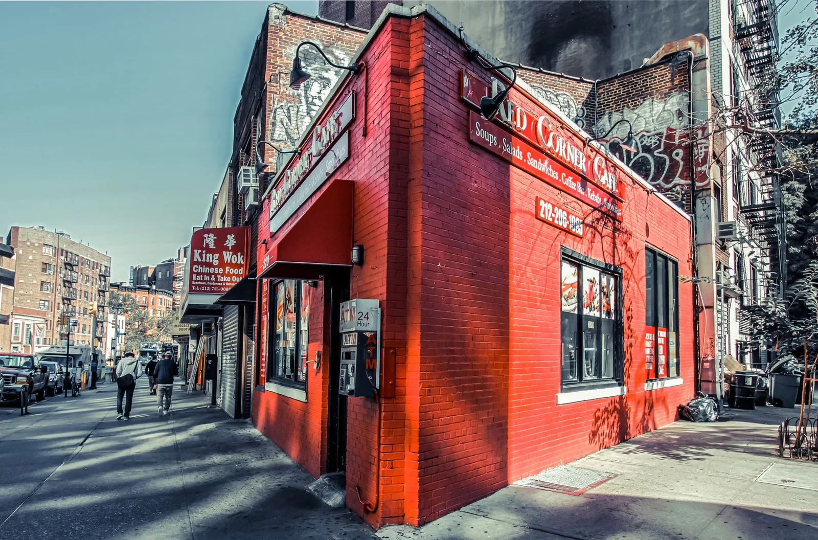 Vibrant red corner cafe in bustling New York City, capturing urban life.