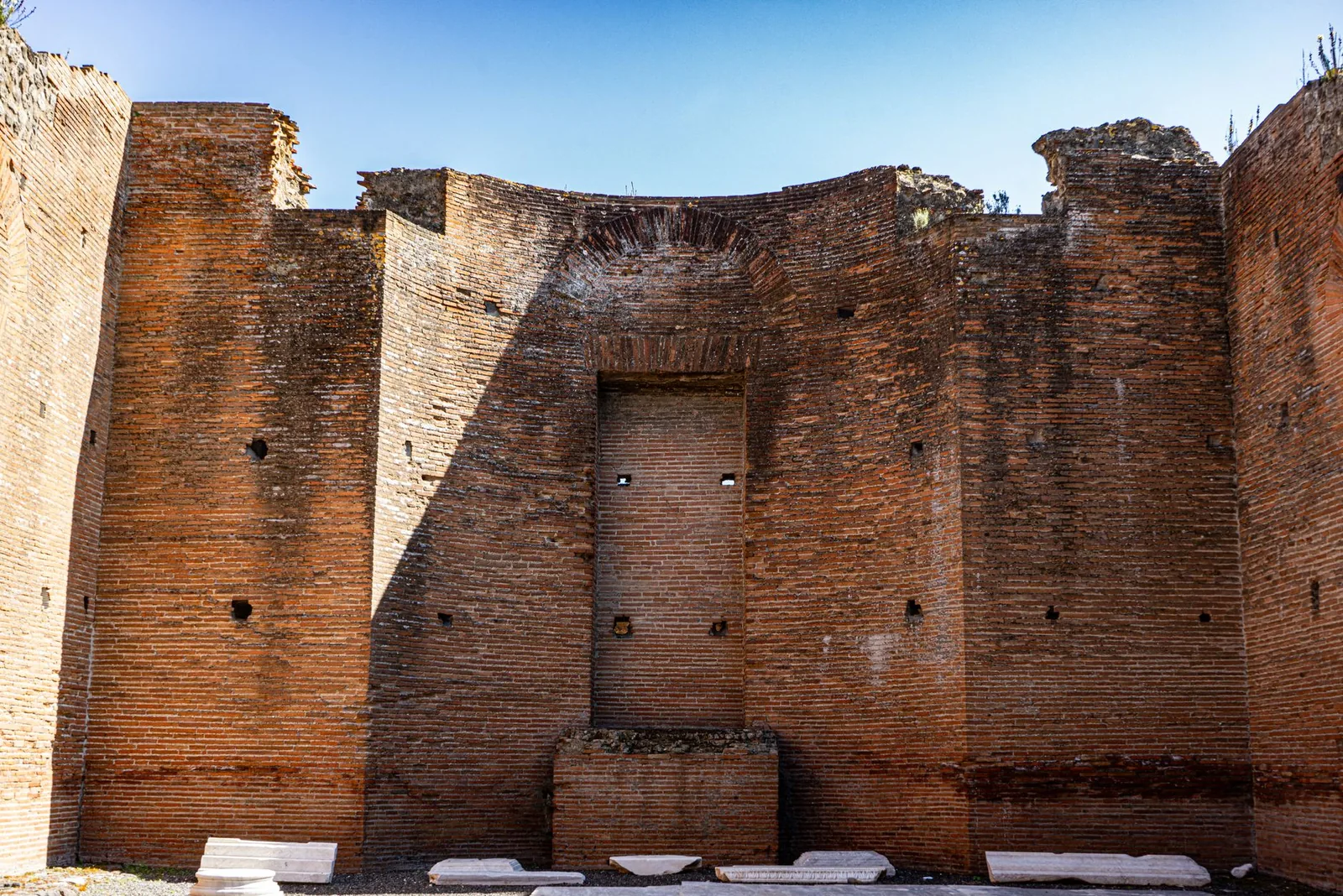 View of historic brick wall ruins in Pompeii, Italy on a sunny day.