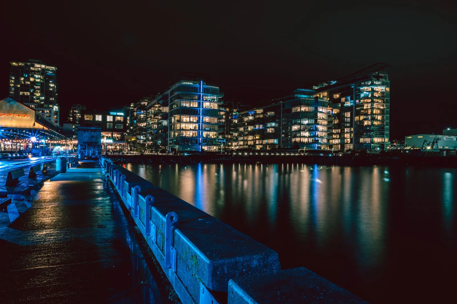 Stunning nighttime view of North Vancouver's illuminated waterfront with cityscape reflections.