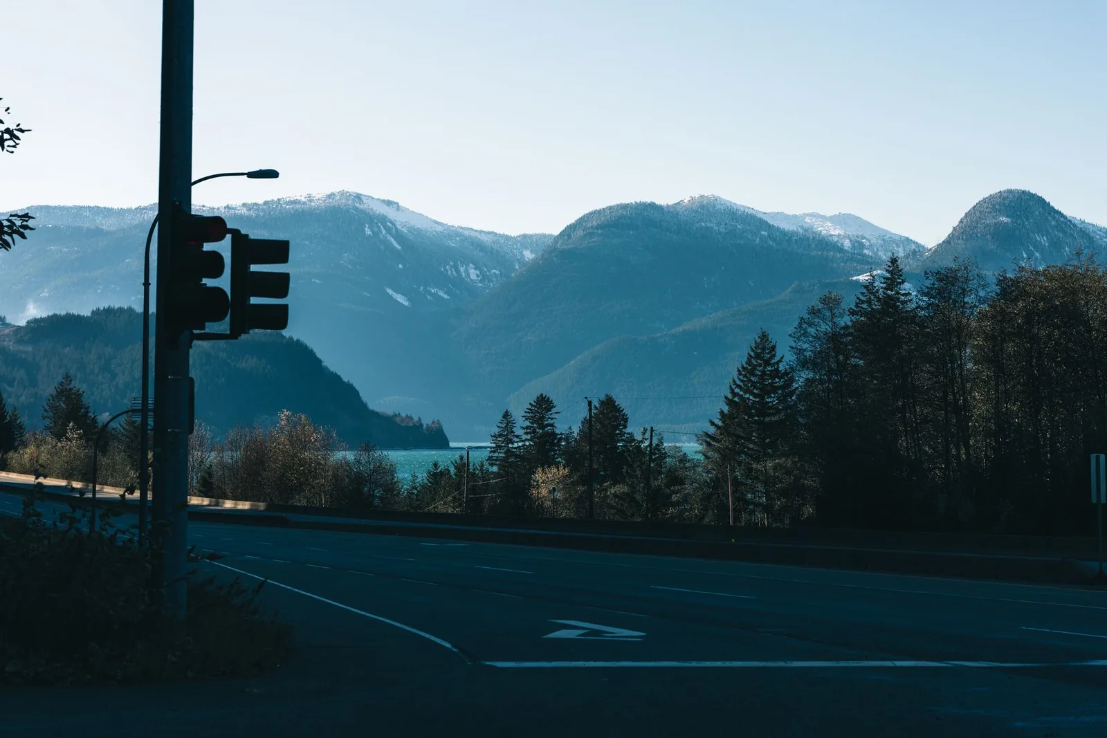 Captivating view of mountains at dawn in Whistler, BC with road and traffic light.